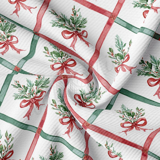 a close-up view of a fabric with a repeating pattern of red and green bows and greenery.