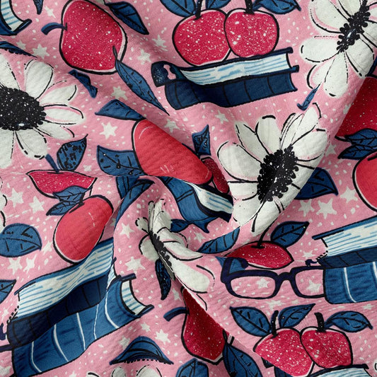 a close up of a pink fabric with flowers and apples on it
