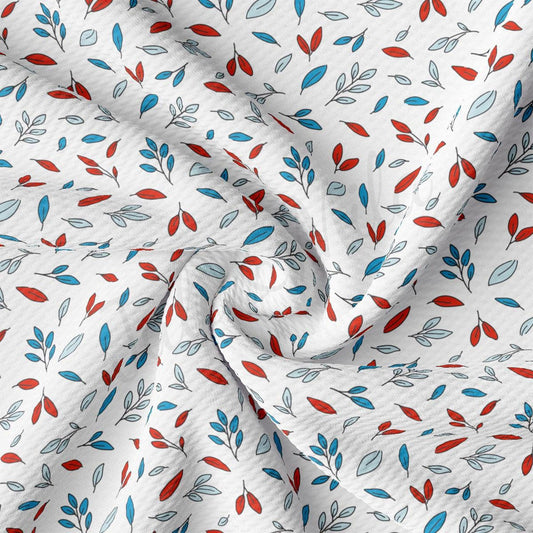 a white fabric with red and blue leaves on it