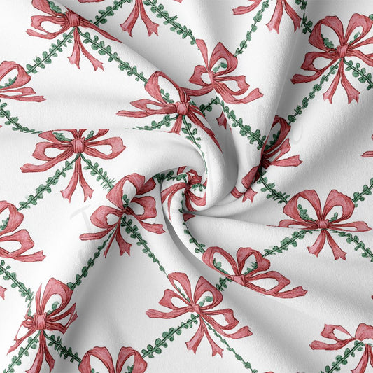 a close-up view of a fabric with a repeating pattern of red bows and green leaves. The bows are arranged in a diagonal pattern, creating a sense of movement and dynamism. The fabric appears to be white, providing a contrast to the vibrant colors of the bows and leaves. The image does not contain any text or other discernible objects, and the relative positions of the bows and leaves remain consistent throughout the pattern.