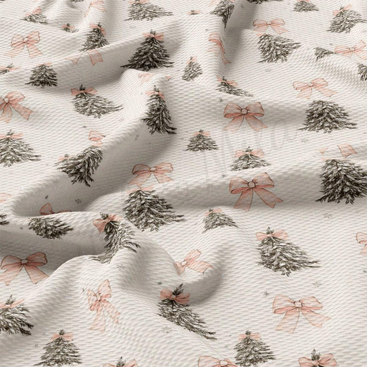 a close-up view of a fabric with a repeating pattern of Christmas trees and pink bows.