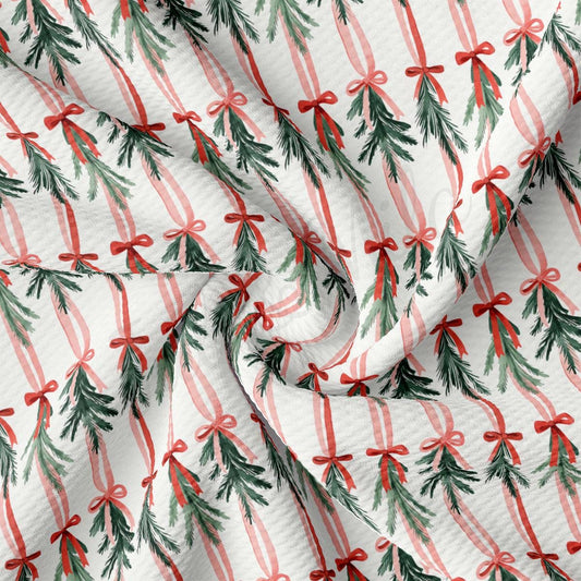 a close-up view of a fabric with a repeating pattern of Christmas trees and red bows.