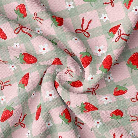 a pink and green checkered fabric with strawberries on it