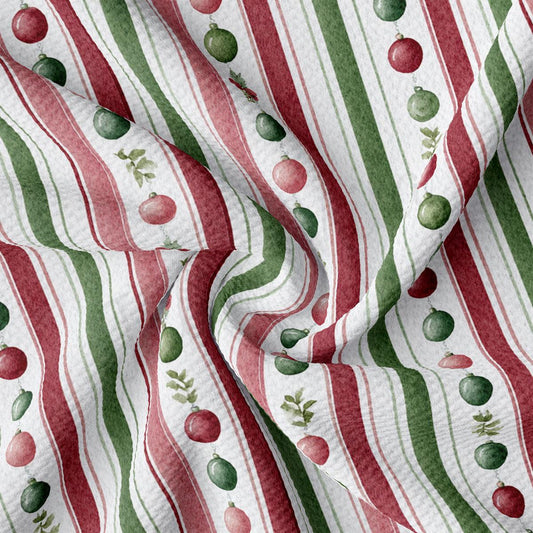 The image is a close-up of a fabric with a repeating pattern of red and green stripes, along with small green and red Christmas ornaments.
