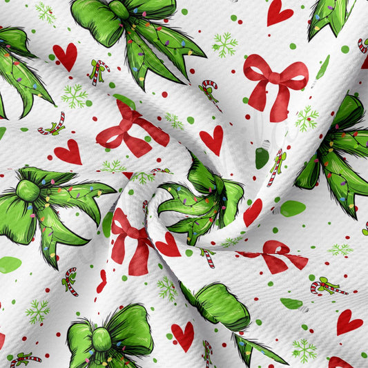 The image is a close-up of a fabric with a repeating pattern of green bows, red bows, and snowflakes.