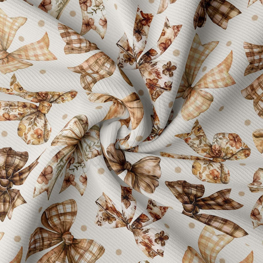 a close-up view of a fabric with a repeating pattern of brown and white bows and flowers. The bows appear to be made of a soft, plaid material, and the flowers are depicted in a realistic style. The fabric has a white background, which contrasts with the brown and white colors of the bows and flowers, making them stand out prominently.
