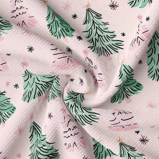 a close-up view of a fabric with a repeating pattern of green Christmas trees and pink stars.