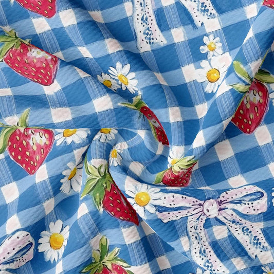 a blue and white checkered fabric with strawberries and daisies