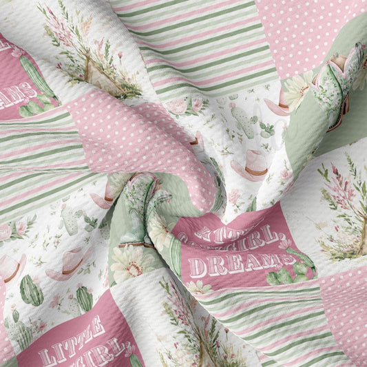 The image is a close-up of a fabric with a floral and polka dot pattern. The fabric appears to be a quilt or textile with a repeating design of pink, green, and white colors.