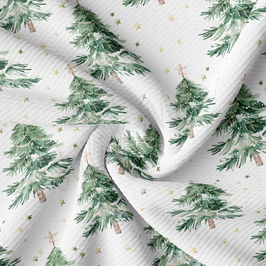 a close-up view of a fabric with a repeating pattern of green Christmas trees and gold stars.