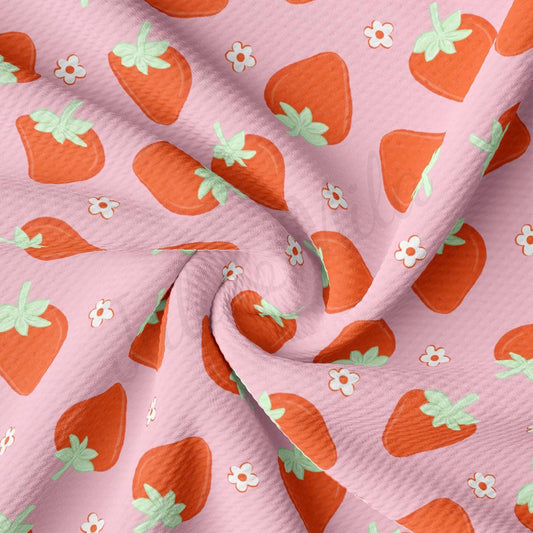 a close up of a pink fabric with a bunch of strawberries on it