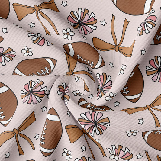 a white fabric with a pattern of footballs and bows