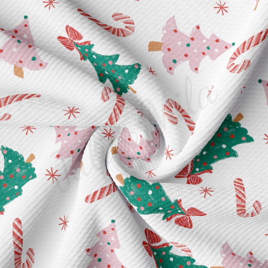 a white fabric with christmas trees and candy canes on it