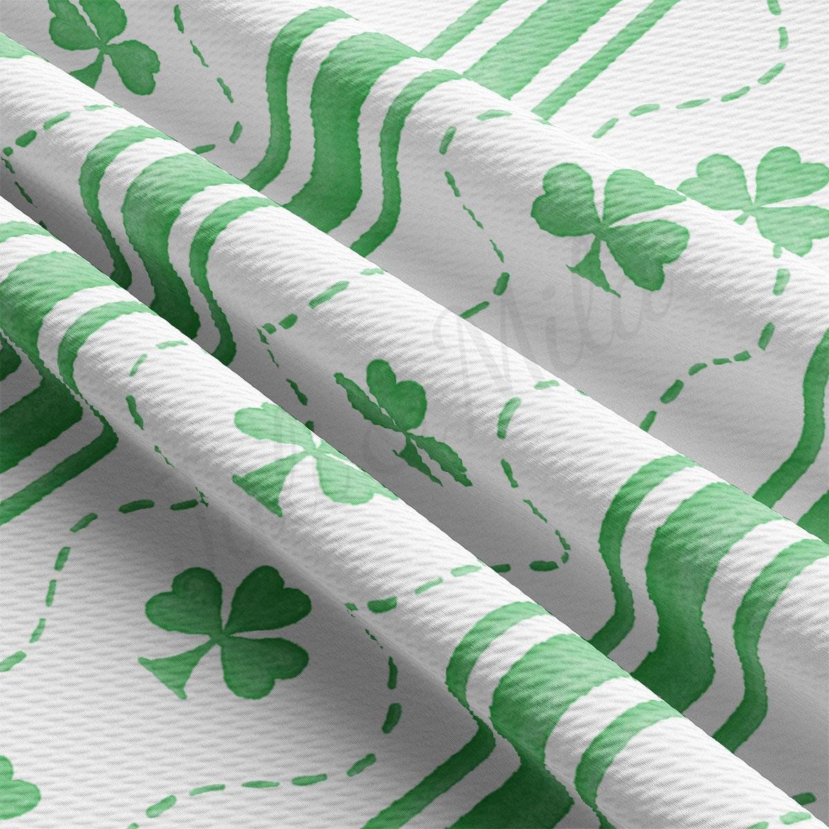 a green and white wallpaper with shamrocks on it