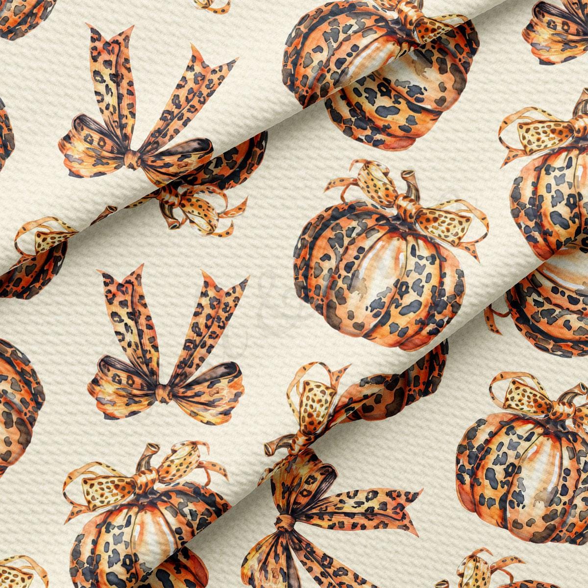 a repeating pattern of leopard print pumpkins with bows on a white background.