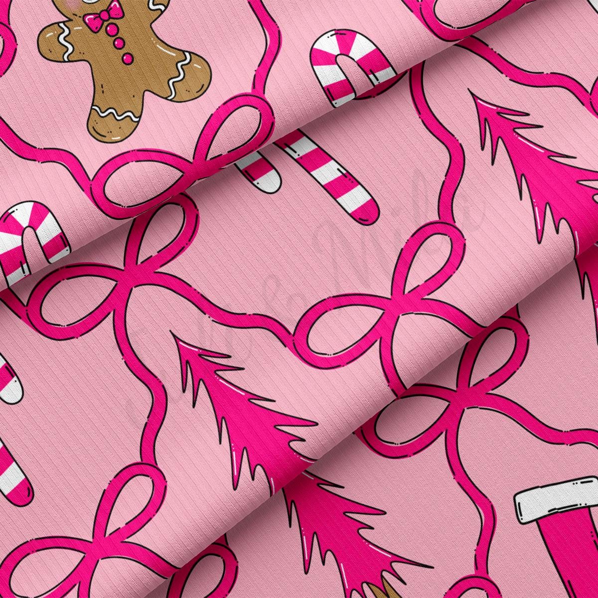 a close-up view of a pink fabric with a repeating pattern of pink bows, candy canes, and a gingerbread man.
