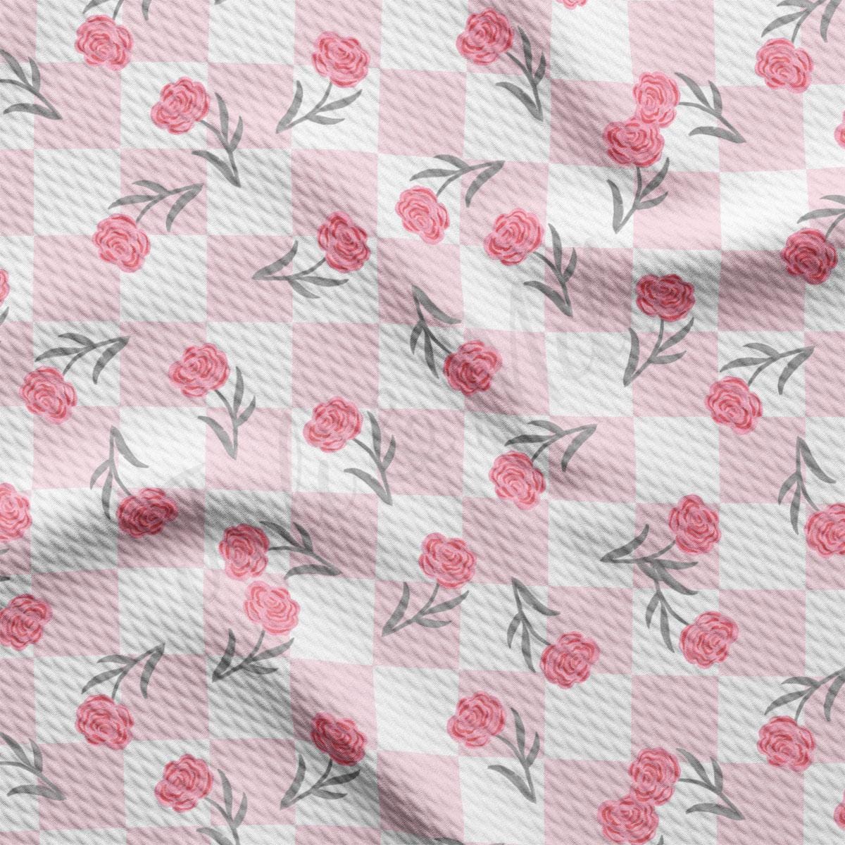 a pink and white checkered fabric with roses on it