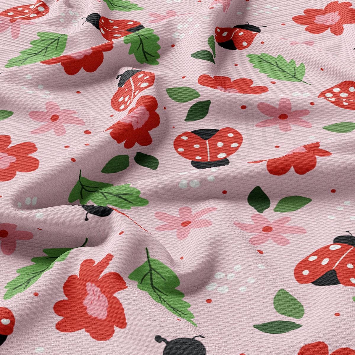 a pink fabric with red flowers and ladybugs on it