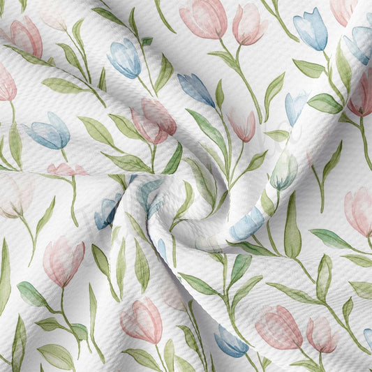 a close-up view of a fabric with a repeating floral pattern of pink, blue, and green flowers and leaves.