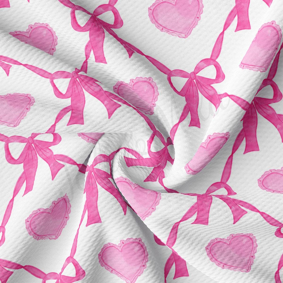 a pink and white fabric with hearts and bows on it
