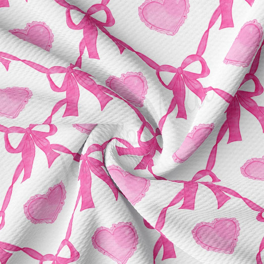 a pink and white fabric with hearts and bows on it