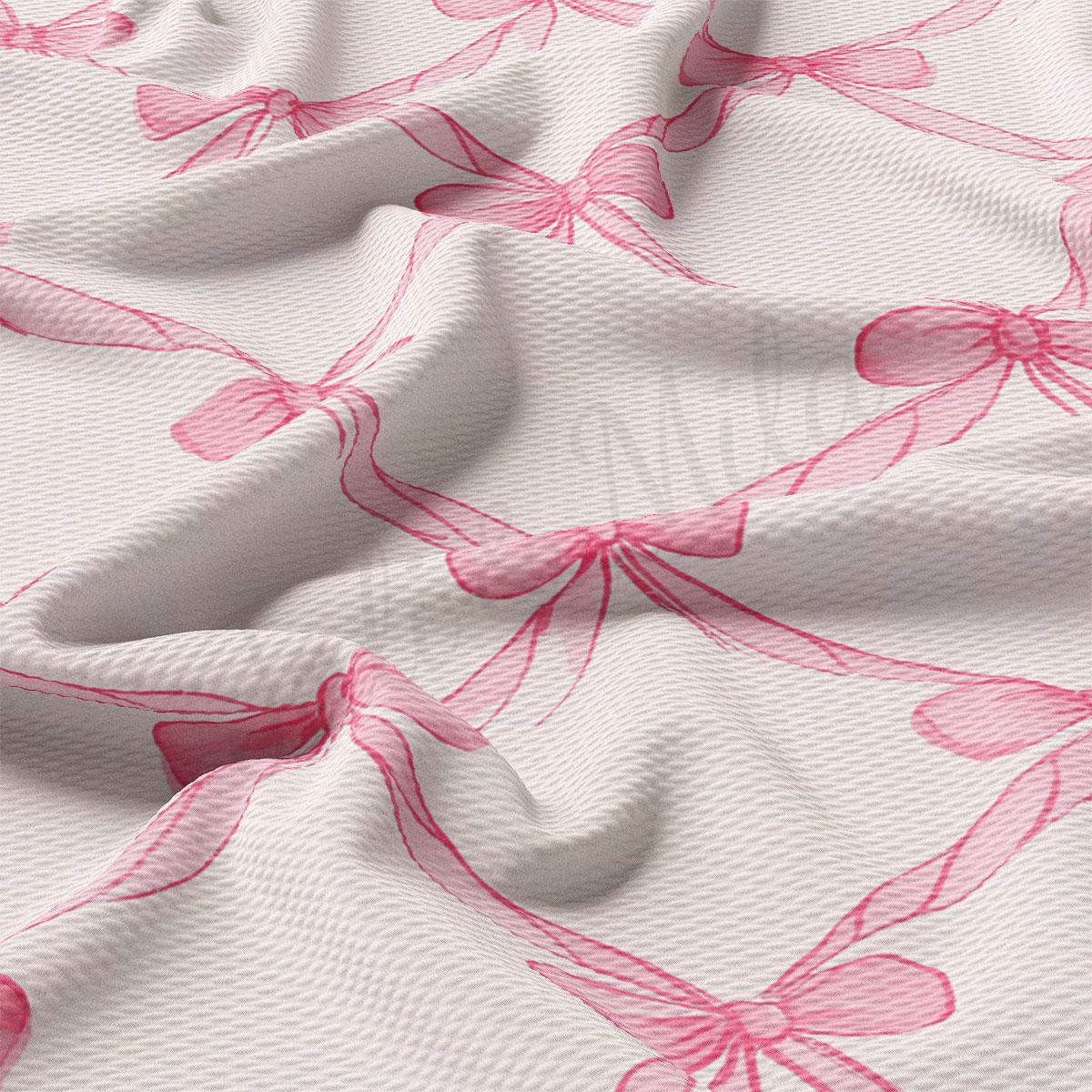 a close-up view of a fabric with a repeating pattern of pink bows on a white background.