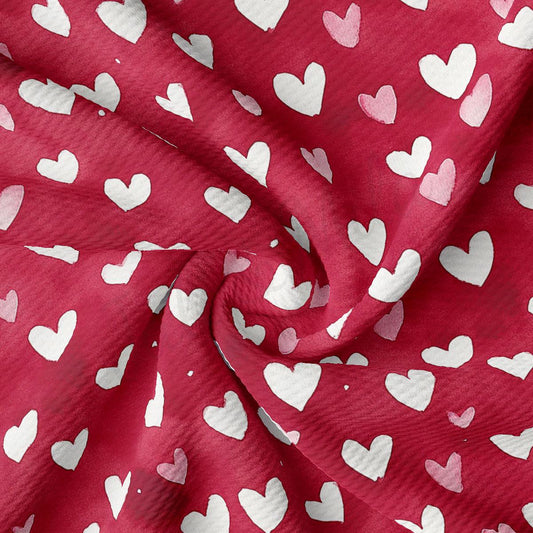 a close-up view of a fabric with a repeating pattern of white hearts against a red background.