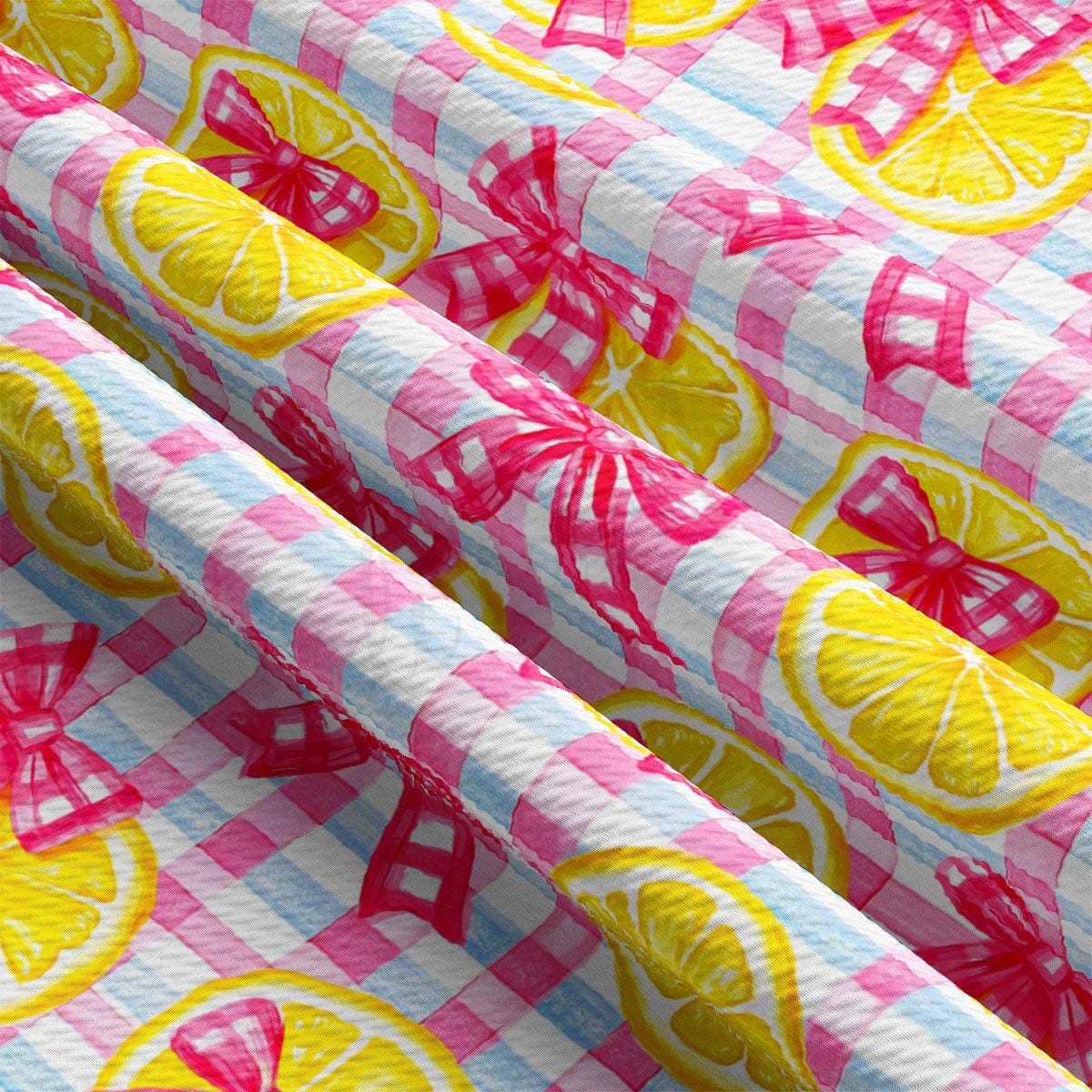 a pink and yellow checkered fabric with lemons on it