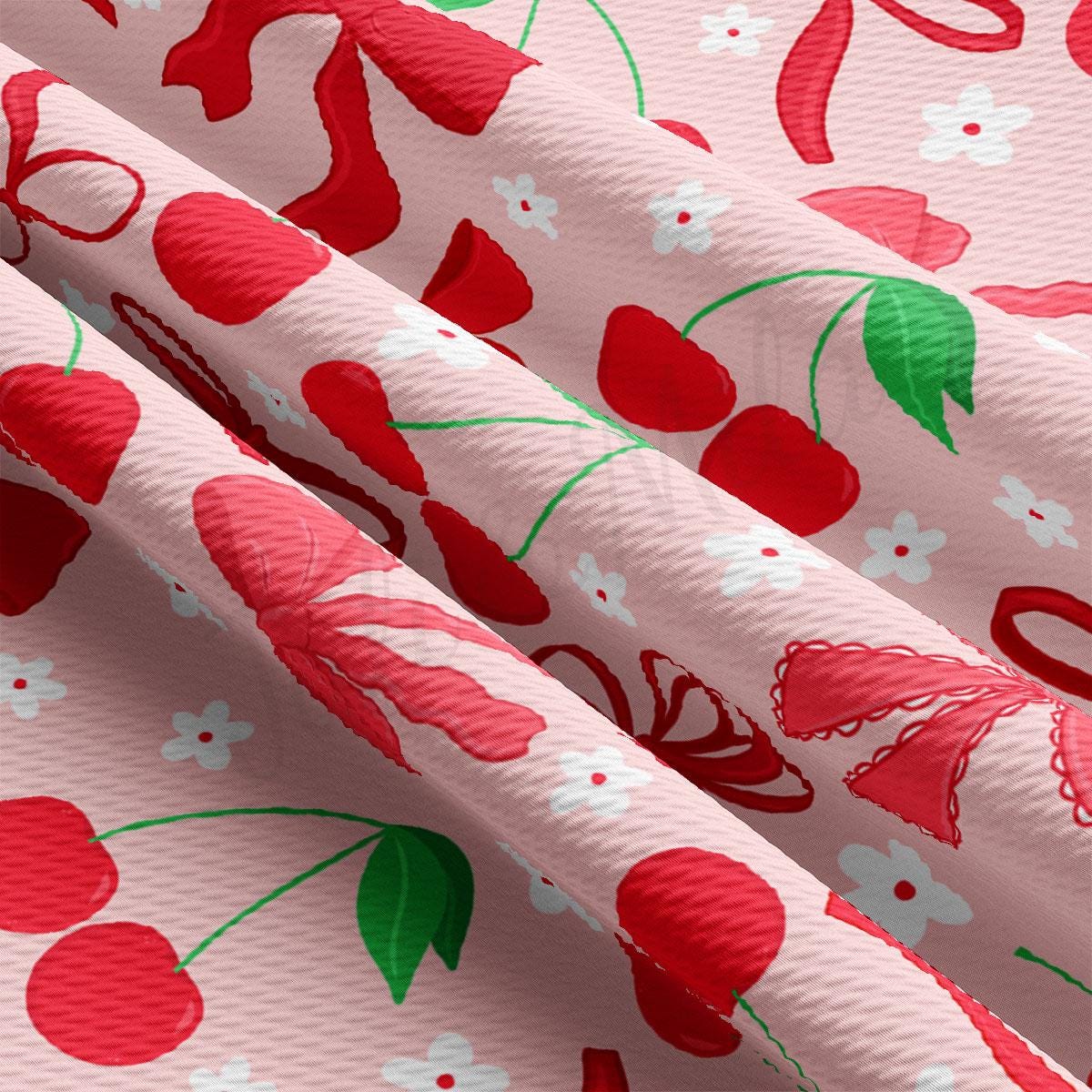 a close up of a pink fabric with cherries on it