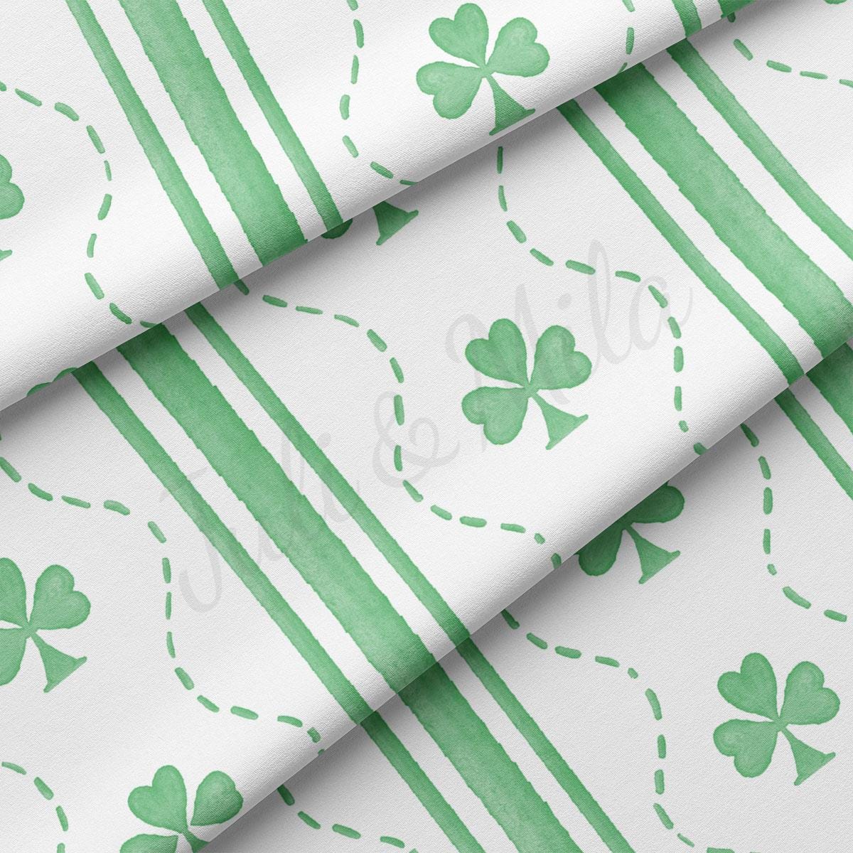 a close up of a green and white paper with shamrocks on it