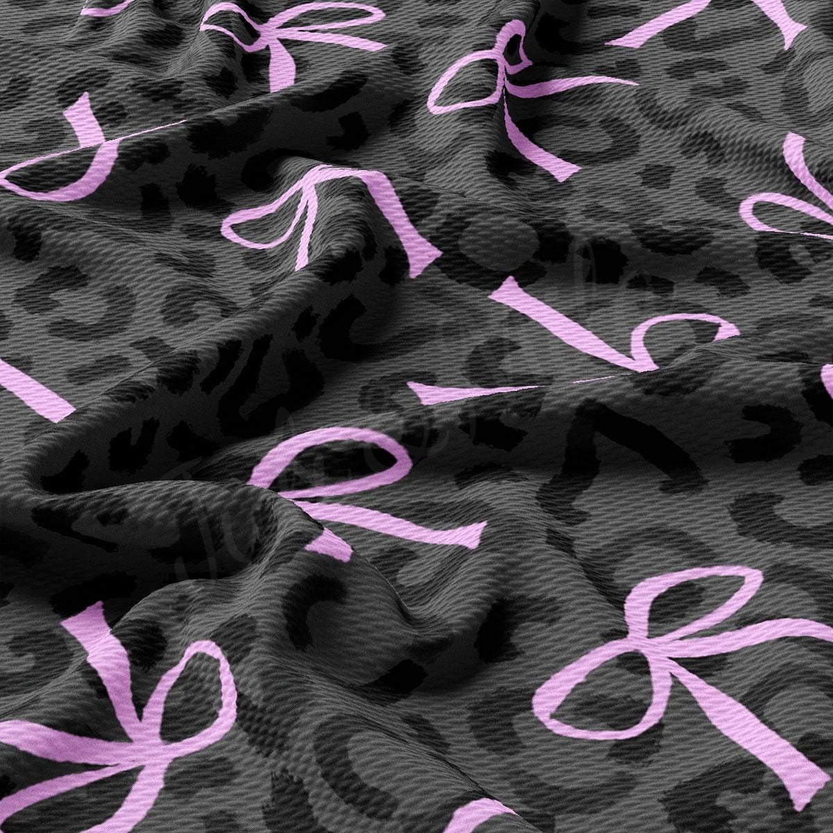 a close up of a pink ribbon on a leopard print fabric