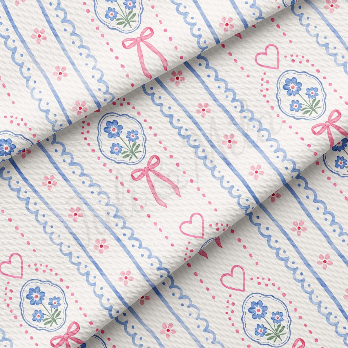 a close-up view of a fabric with a repeating pattern of blue and pink flowers, hearts, and bows. The pattern is composed of vertical and horizontal lines, creating a visually appealing and intricate design.