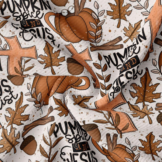 The image is a close-up of a fabric with a repeating pattern of autumn-themed elements, including pumpkins, leaves, and spices. The pattern is predominantly brown and orange, with some black text and illustrations.