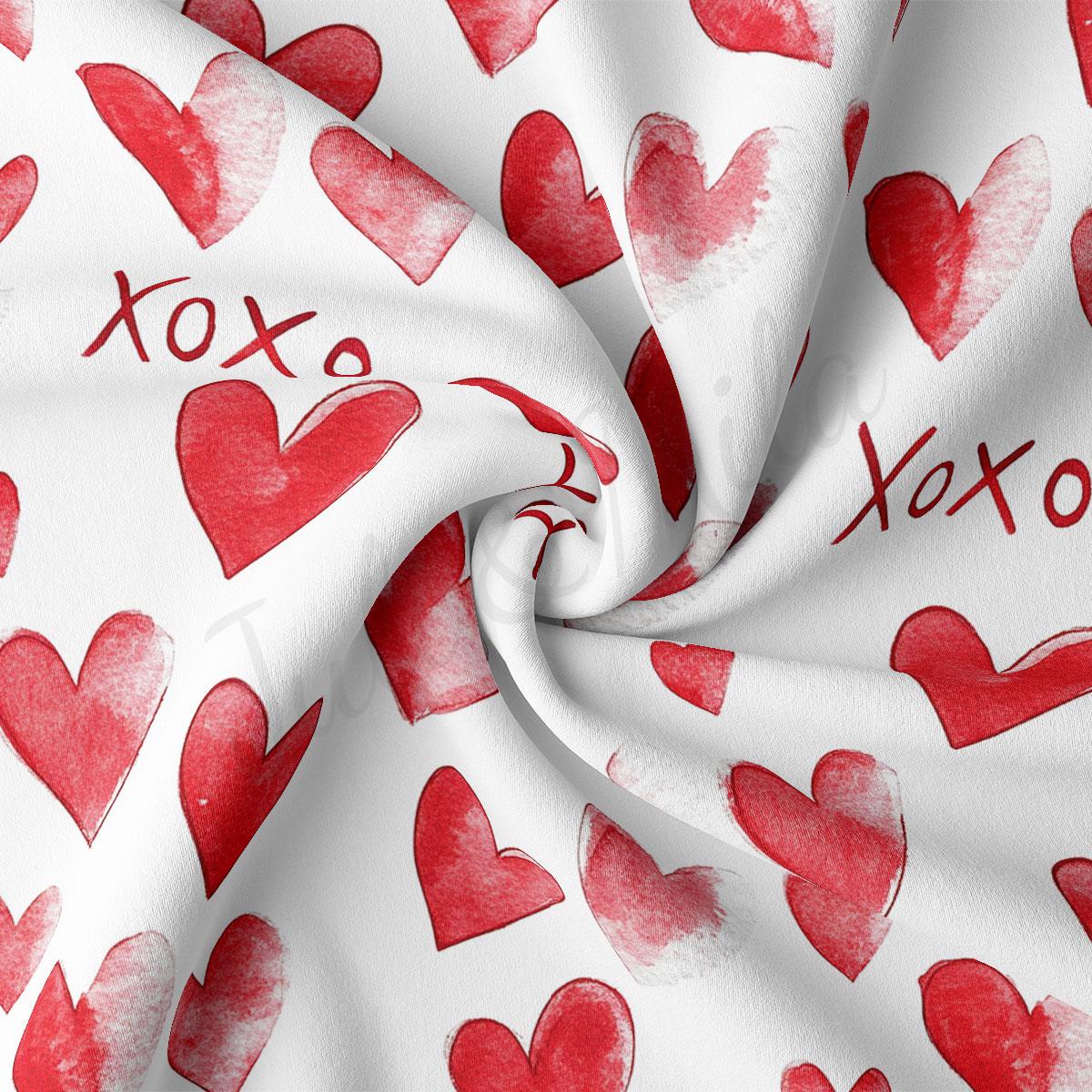 a close-up view of a fabric with a repeating pattern of red hearts on a white background.