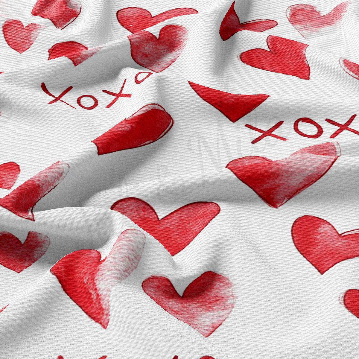 a close-up view of a white fabric with a repeating pattern of red hearts and the word "XOX" written in red.