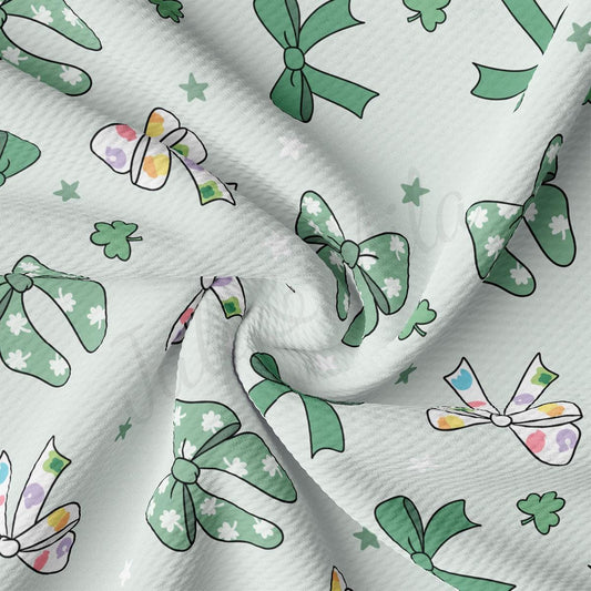 a close up of a white fabric with green bows