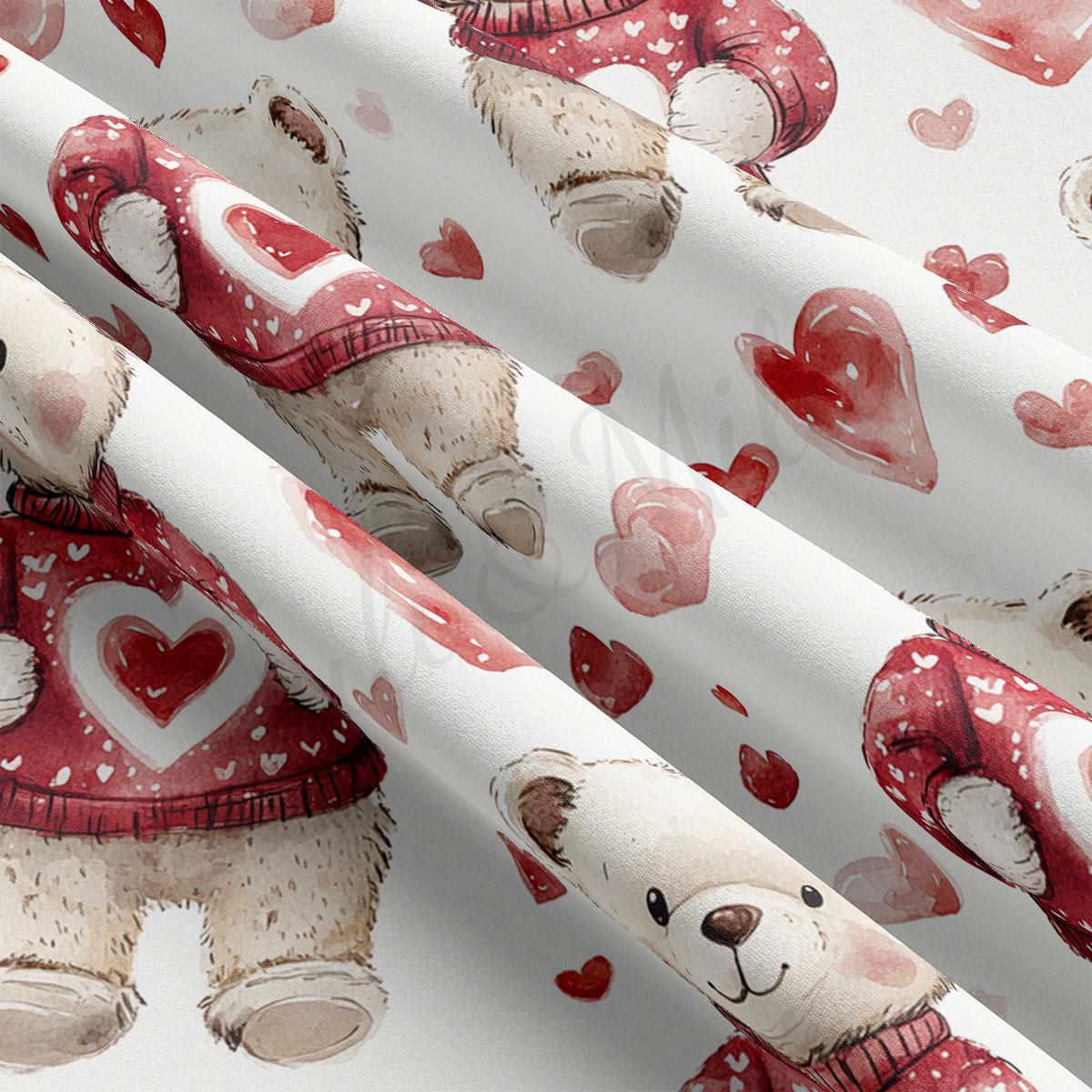 a close-up view of a fabric with a repeating pattern of teddy bears wearing red sweaters with hearts on them.