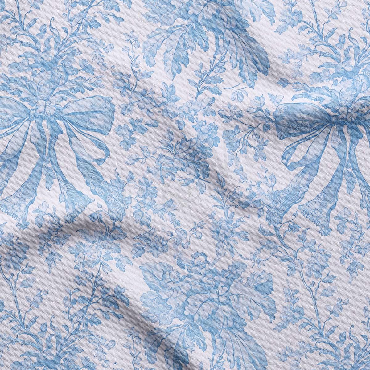 a close-up view of a fabric with a blue floral pattern. The fabric appears to be wrinkled, giving it a textured appearance. The pattern consists of various blue flowers and leaves, creating a visually appealing and intricate design.
