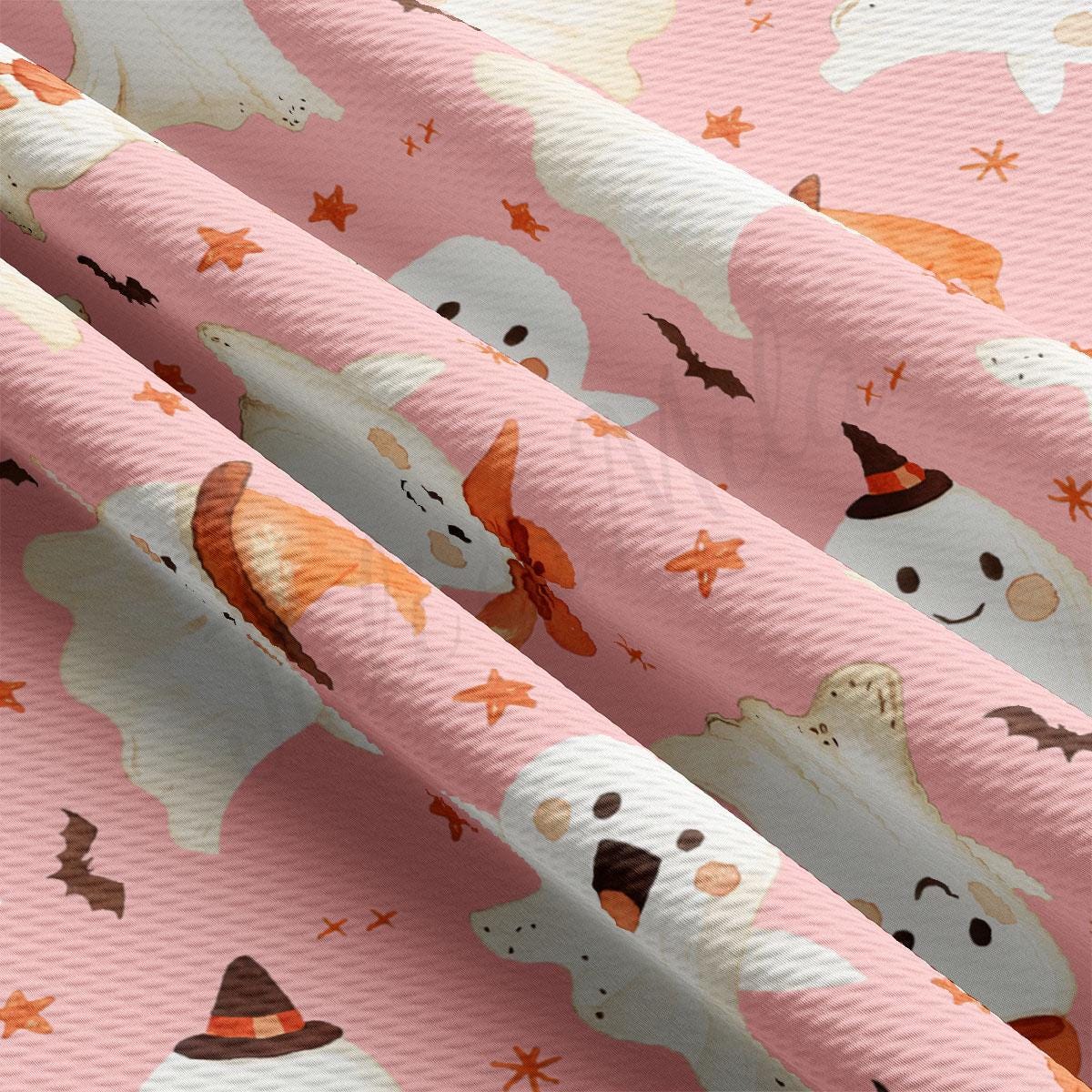 a close-up view of a fabric with a repeating pattern of ghost-like figures and stars in shades of pink and orange.