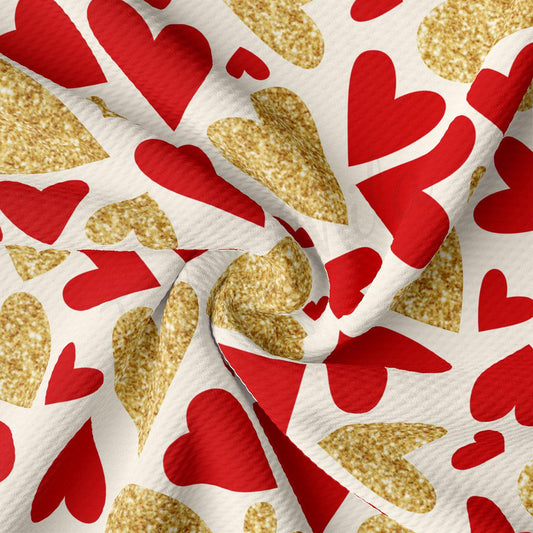 a close-up view of a fabric with a repeating pattern of red and gold hearts. The hearts are arranged in a diagonal pattern, creating a sense of movement and dynamism. The fabric appears to be made of a soft, plush material, and the red and gold colors stand out prominently against the white background.