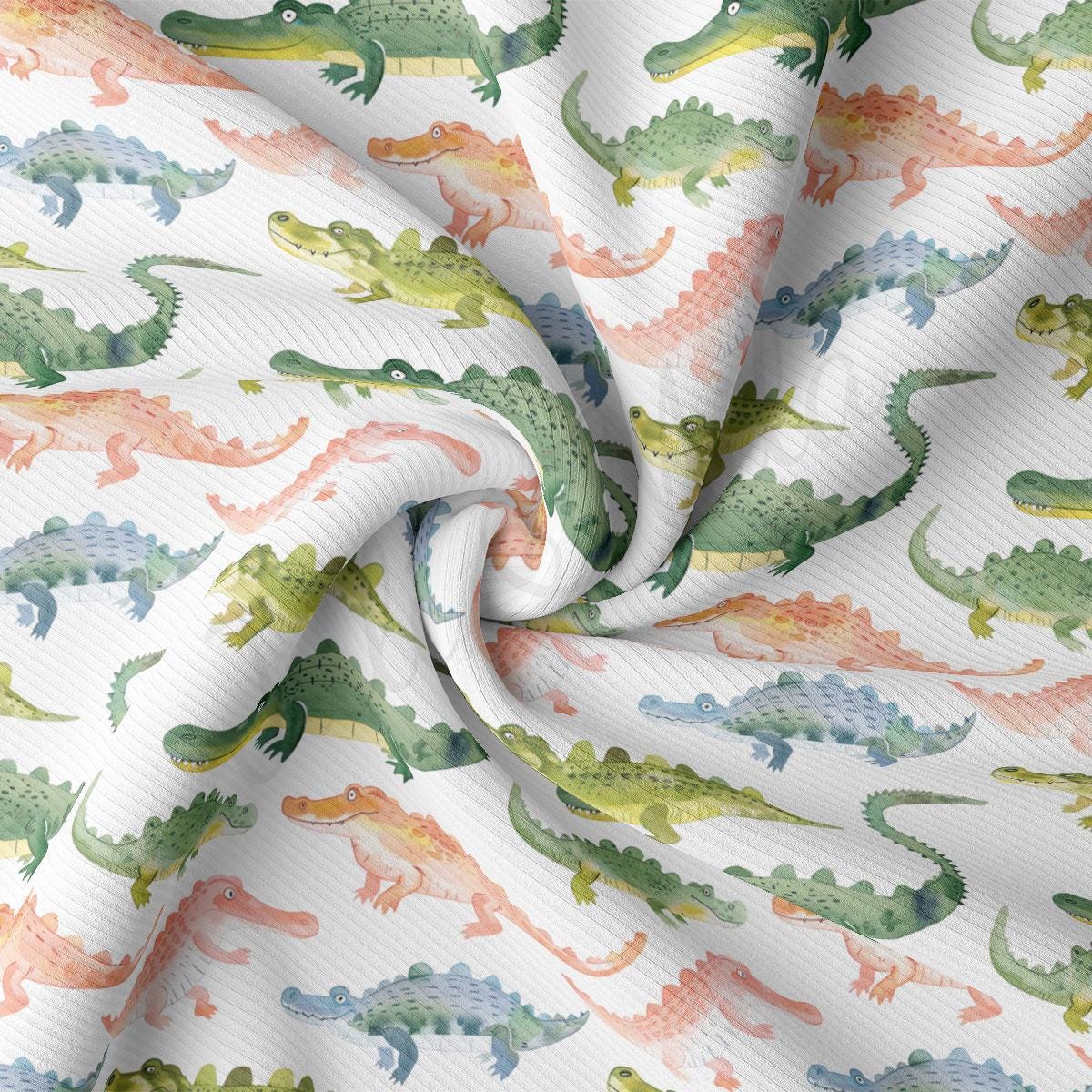 a close up of a white fabric with green and orange dinosaurs on it