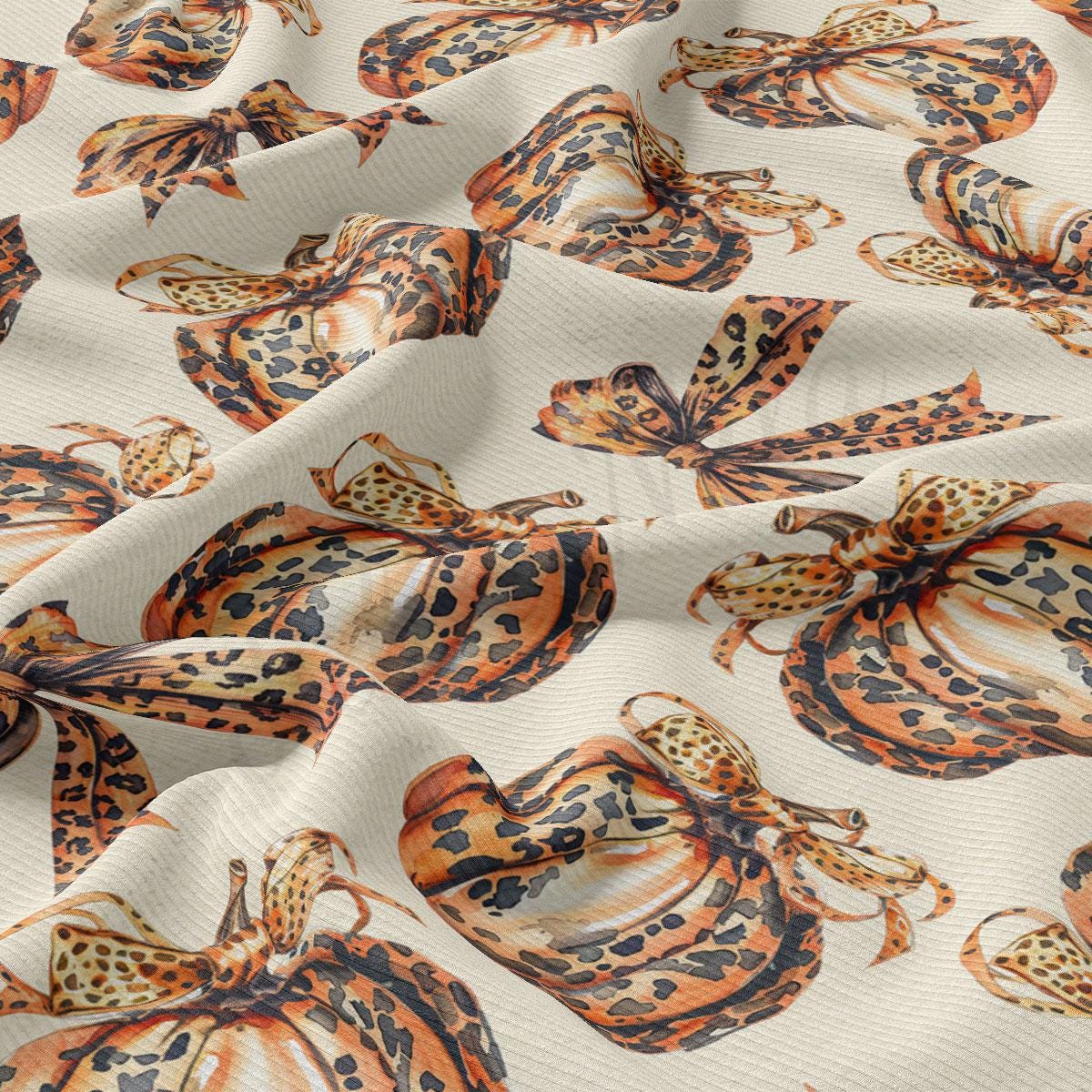 a close-up view of a fabric with a repeating pattern of leopard-print designs, including butterflies and pumpkins.