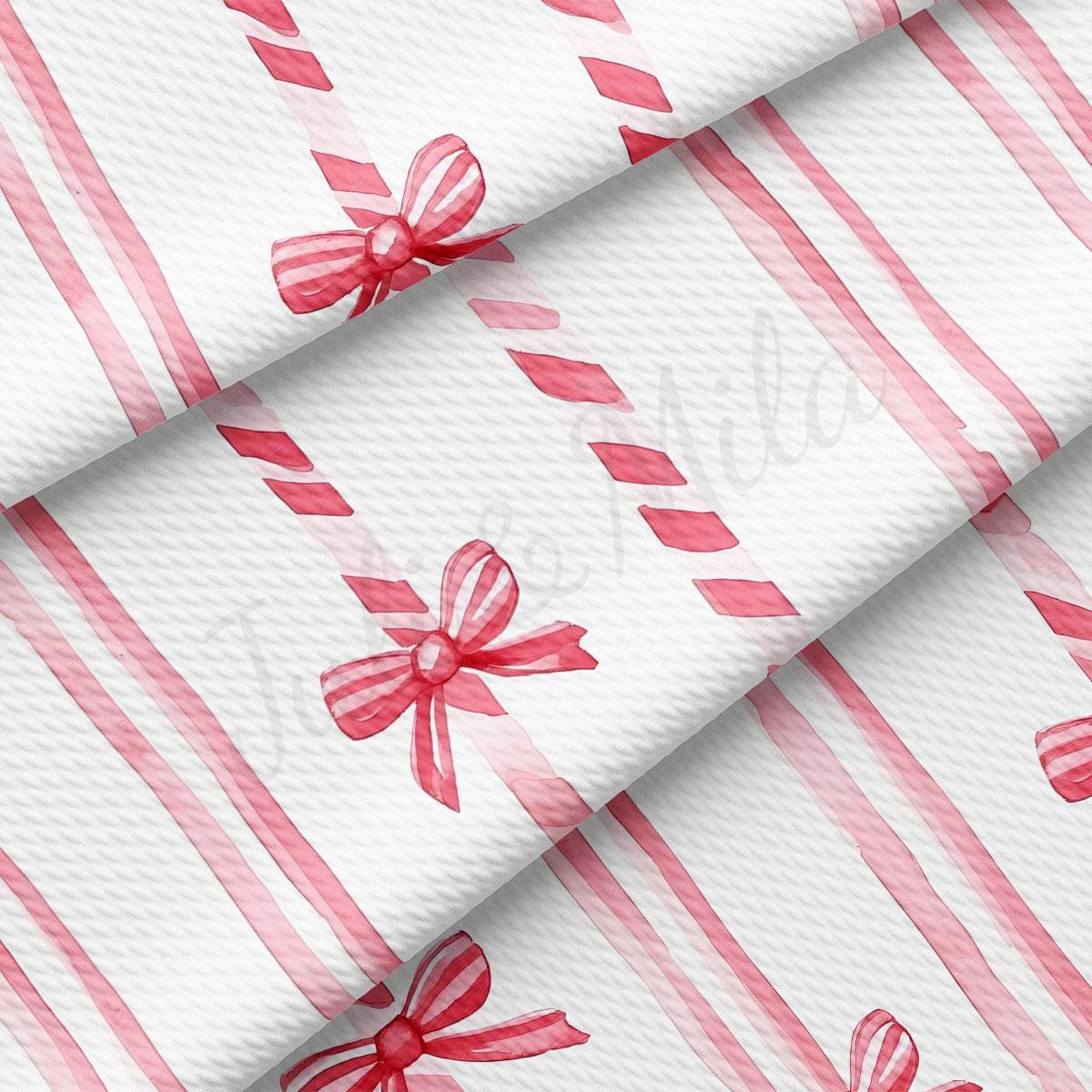 a close-up view of a fabric with a repeating pattern of red and white stripes, along with a bow design.