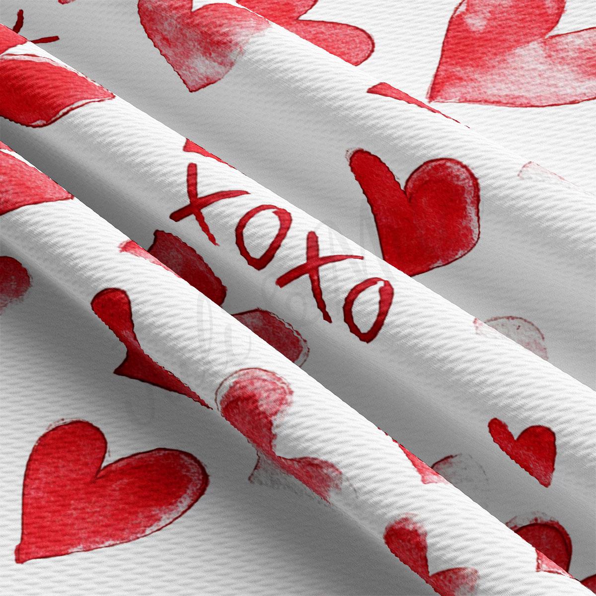 a close-up view of a fabric with a repeating pattern of red hearts.