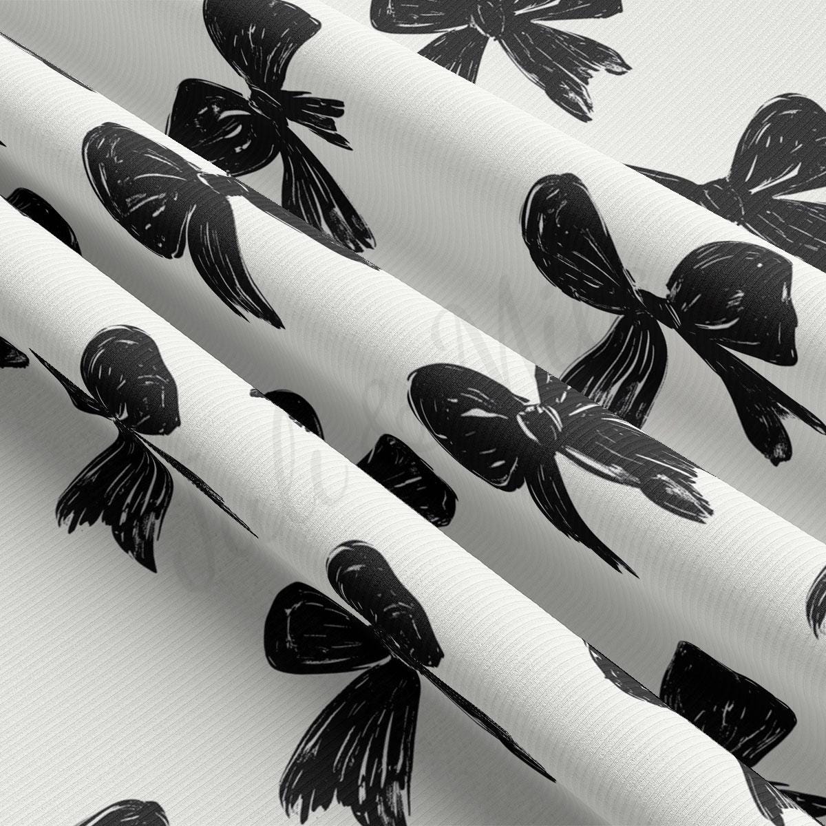 a close-up view of a fabric with a repeating pattern of black bows on a white background.