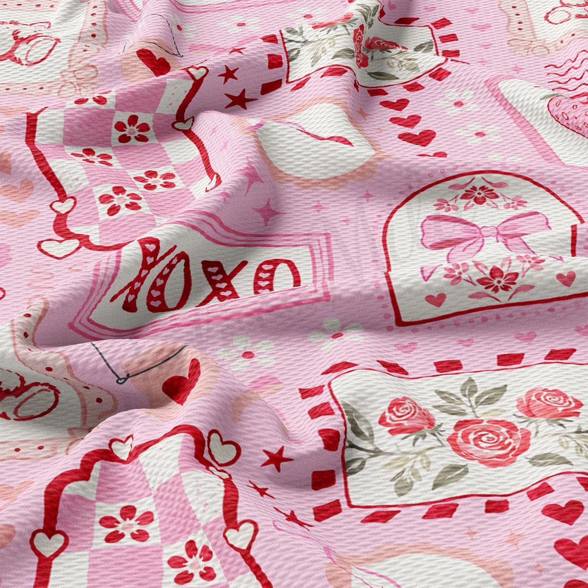 The image is a close-up of a fabric with a pink and white color scheme, featuring various patterns and designs such as hearts, flowers, and stars.