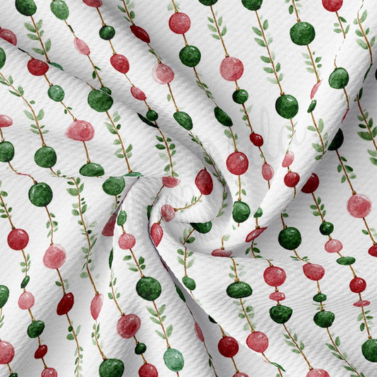 a close-up view of a fabric with a repeating pattern of red and green circles and green leaves.