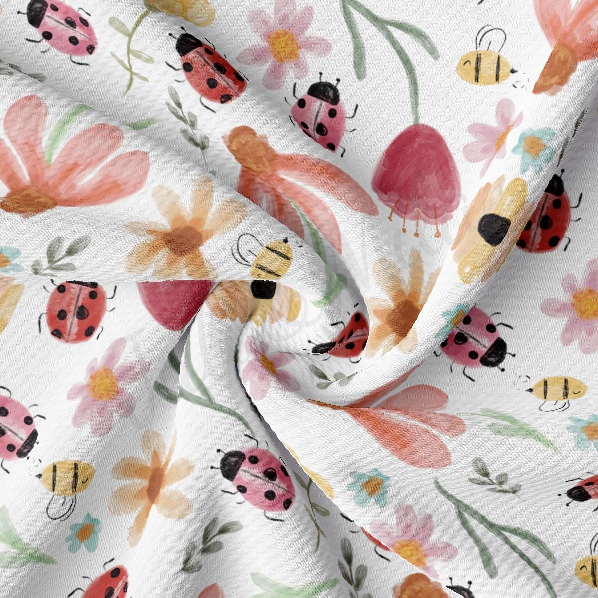 a white fabric with ladybugs and flowers on it