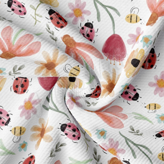 a white fabric with ladybugs and flowers on it