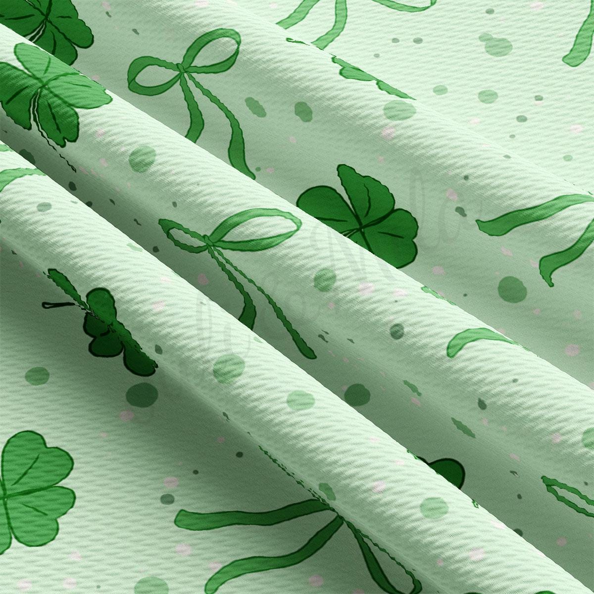 a close up of a green and white fabric with shamrocks on it